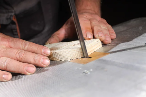 Un artesano cortando una tabla de madera con sierra de cinta — Foto de Stock