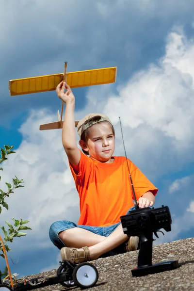 Kleine jongen spelen met handgemaakte rc vliegtuig speelgoed — Stockfoto