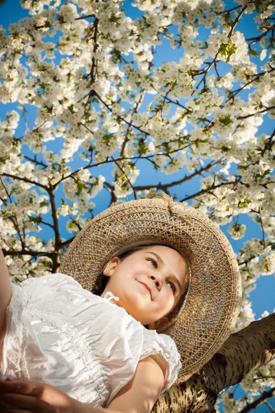 Nettes kleines Mädchen spielt auf Baum im zeitigen Frühling — Stockfoto