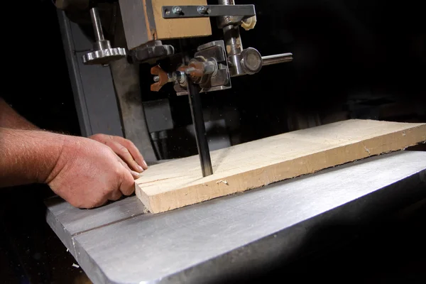 Un artesano cortando una tabla de madera con sierra de cinta —  Fotos de Stock