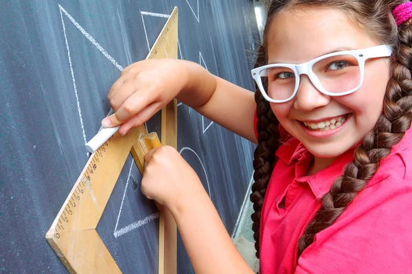 Happy school girl in front of the blackboard — Stock Photo, Image