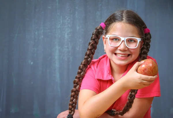 Happy school girl in front of the blackboard — Stock Photo, Image