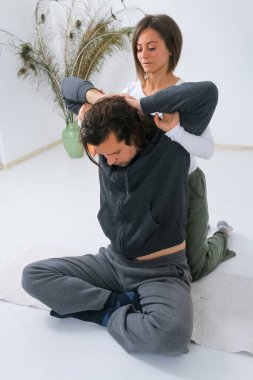 Shiatsu masözünden yetişkin bir adam Shiatsu masajı yaptırıyor.