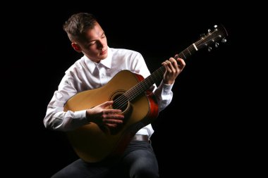 Siyah arka planda gitar çalan genç adamlar