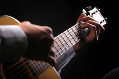 Siyah arka planda gitar çalan genç adamlar