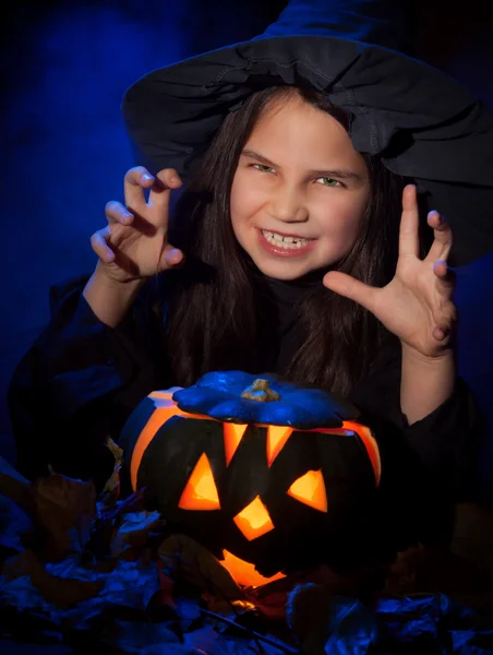 A bruxinha com abóbora de Halloween — Fotografia de Stock