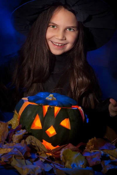 A bruxinha com abóbora de Halloween — Fotografia de Stock