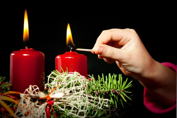 Lightning the candles on advent wreath — Stock Photo, Image