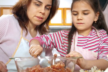 Anne ve kızı öğle yemeği için et hazırlamak