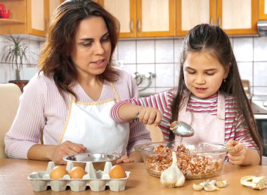 Anne ve kızı öğle yemeği için et hazırlamak