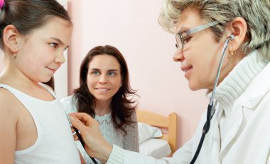 Doktor bir çocuğun bir hastanede muayene
