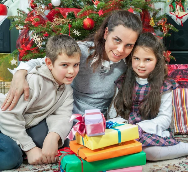 Famille échangeant des cadeaux devant l'arbre de Noël — Photo