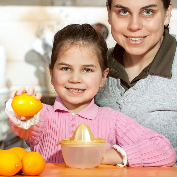 Mulher e filha fazendo suco de frutas frescas — Fotografia de Stock