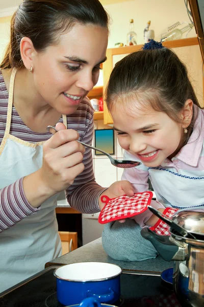 Meisje helpen haar moeder in de keuken — Stockfoto