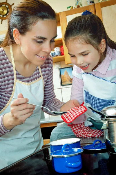 Liten flicka hjälpa mamma i köket — Stockfoto
