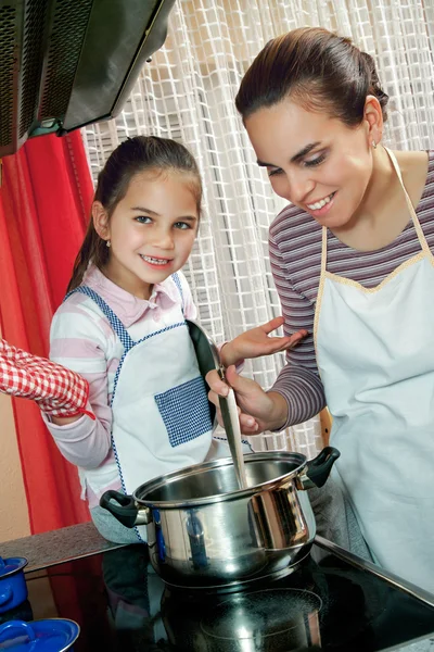 小女孩帮助她的妈妈在厨房里 — 图库照片
