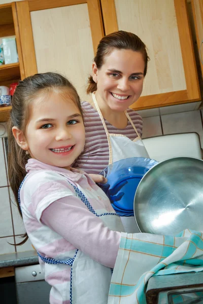Liten flicka hjälpa mamma i köket — Stockfoto