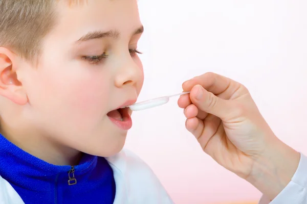 Kleine jongen drinken siroop geneeskunde vloeistof — Stockfoto