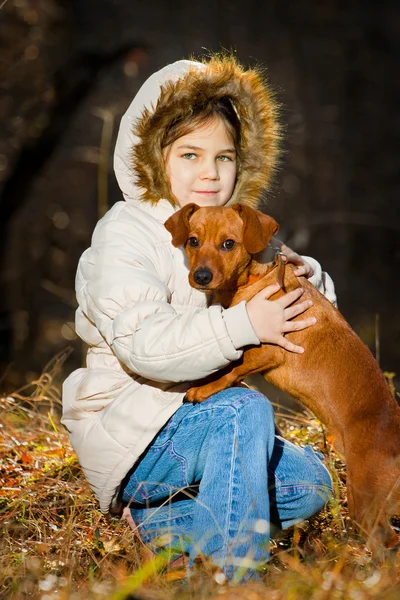 Sonbaharda büyük köpek ormandaki oynamaktan mutlu küçük kız — Stok fotoğraf