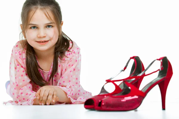 Portrait of little girl with high-heeled shoes — Stock Photo, Image