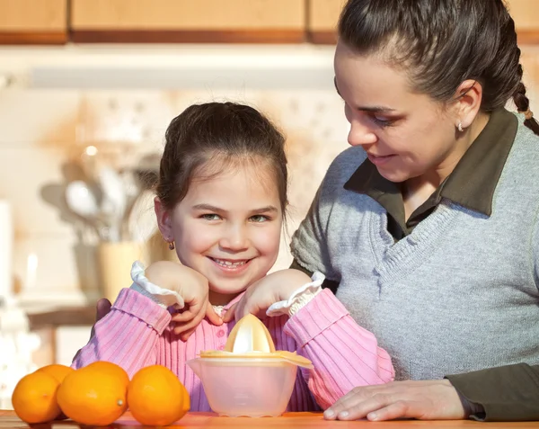 Vrouw en dochter maken vers vruchtensap — Stockfoto