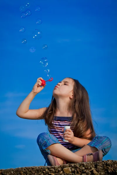 Petite fille soufflant bulles de savon — Photo