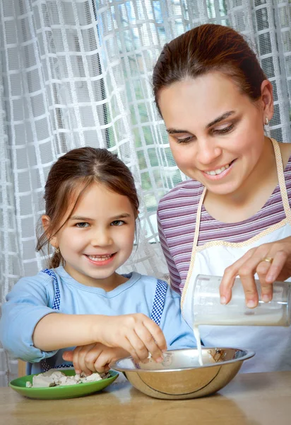 小さな女の子が母親とランチのピザを作る — ストック写真