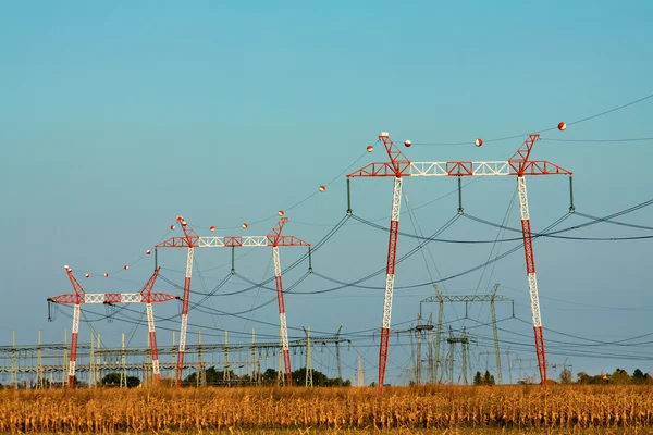 Yüksek gerilim enerji iletim hatları ve pilonlar silueti bir — Stok fotoğraf