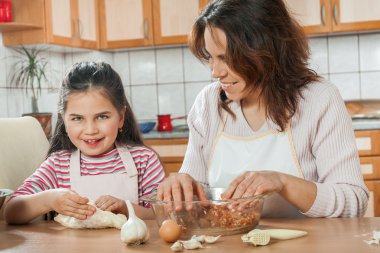 Anne ve kızı öğle yemeği için et hazırlamak