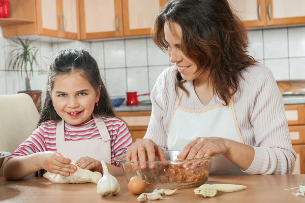 Mor och dotter förbereda kött till lunch — Stockfoto