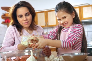 Anne ve kızı öğle yemeği için et hazırlamak