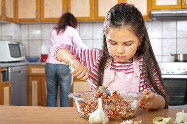Anne ve kızı öğle yemeği için et hazırlamak