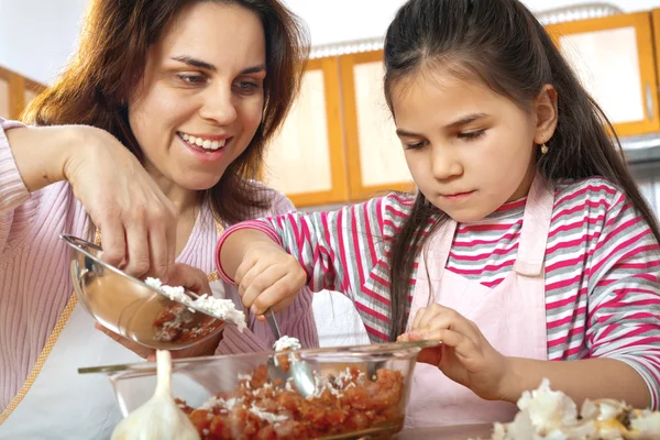 Mother and daughter prepare meat for lunch — Stock Photo, Image
