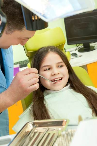 Niña sentada en el consultorio de dentistas — Foto de Stock