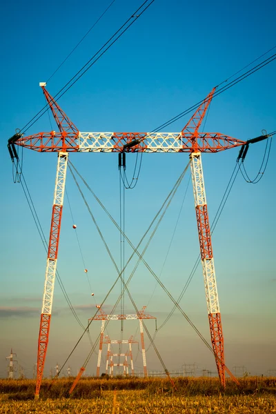 Silhouette of high voltage power transmission lines and pylons a — Stock Photo, Image