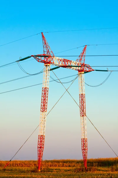 Yüksek gerilim enerji iletim hatları ve pilonlar silueti bir — Stok fotoğraf