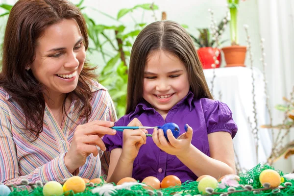 Mother and her children paint easter eggs — Stock Photo, Image