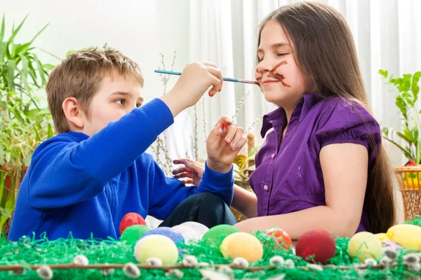 Mother and her children paint easter eggs — Stock Photo, Image