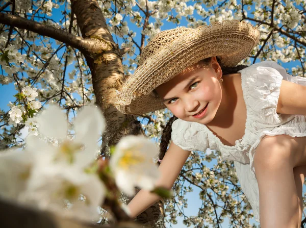 Nettes kleines Mädchen spielt auf Baum im zeitigen Frühling — Stockfoto