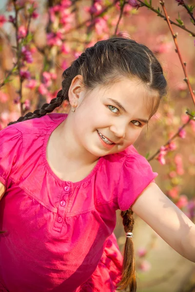 Schattig klein meisje spelen op boom in het vroege voorjaar — Stockfoto