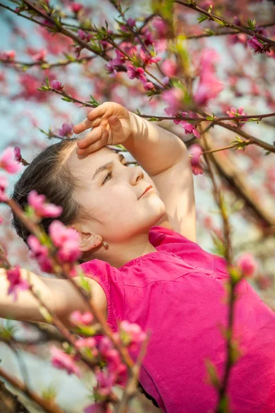 Cute little girl playing on tree in early spring — Stock Photo, Image