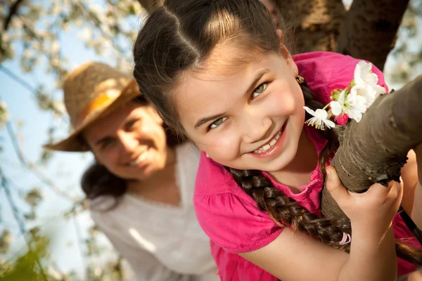 Aranyos kis lány játszik a fa kora tavasszal — Stock Fotó