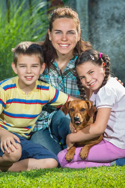 Красивая семья матери, сына и дочери со своей собакой , — стоковое фото