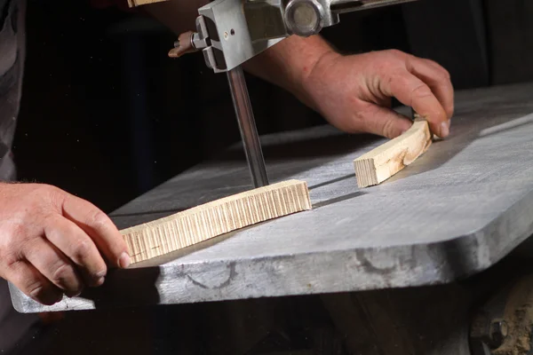 Un artesano cortando una tabla de madera con sierra de cinta —  Fotos de Stock