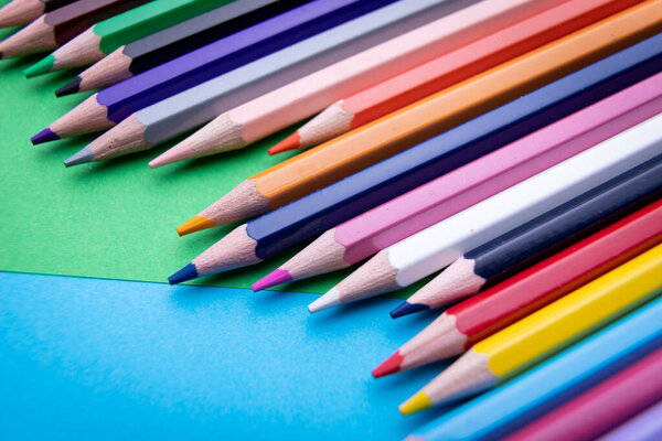 Цветной набор карандашей изолирован на синем и зеленом фоне
