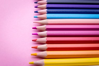 Pembe arkaplanda izole edilmiş renkli kalem seti