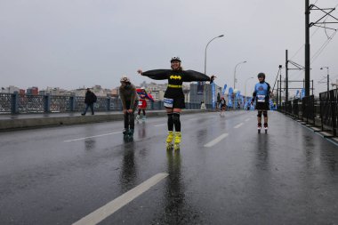 ISTANBUL, TURKEY - Nisan 04, 2021: Galata Köprüsü 'nde İstanbul Yarı Maratonu' nda koşan patenci