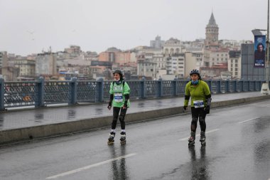 ISTANBUL, TURKEY - Nisan 04, 2021: Galata Köprüsü 'nde İstanbul Yarı Maratonu' nda koşan patenci