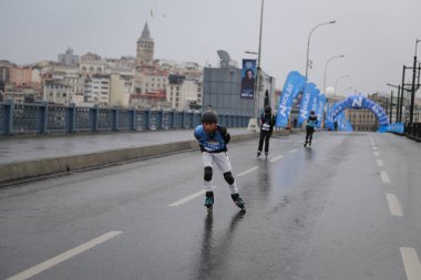 ISTANBUL, TURKEY - Nisan 04, 2021: Galata Köprüsü 'nde İstanbul Yarı Maratonu' nda koşan patenci