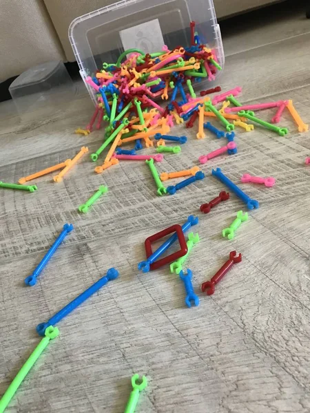 Çocukların inşaatçısının renkli detayları yerlere saçılmış.